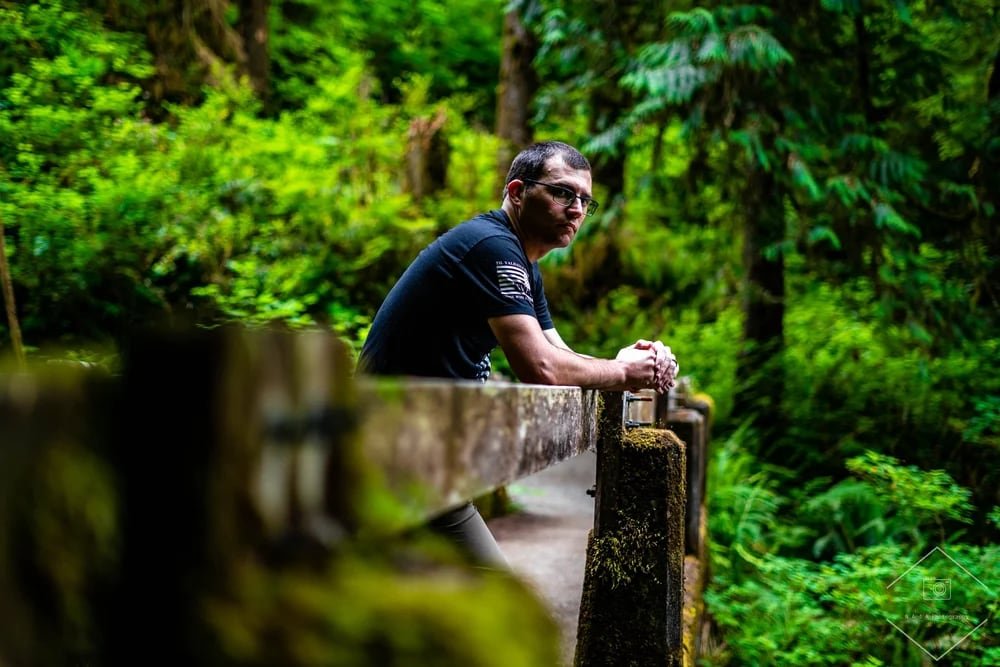 Anthony, one half of N&A Photography, on a forest bridge